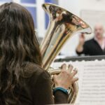 a woman playing a brass instrument in a orchestra