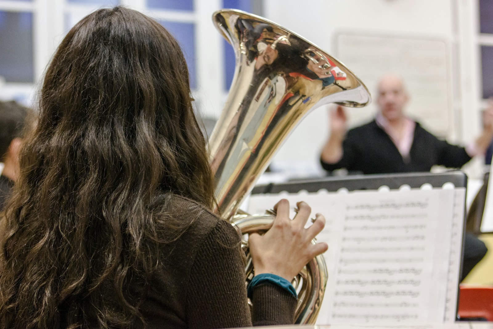 a woman playing a brass instrument in a orchestra
